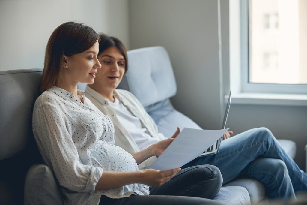 A couple sitting on a sofa talking about their birth plan